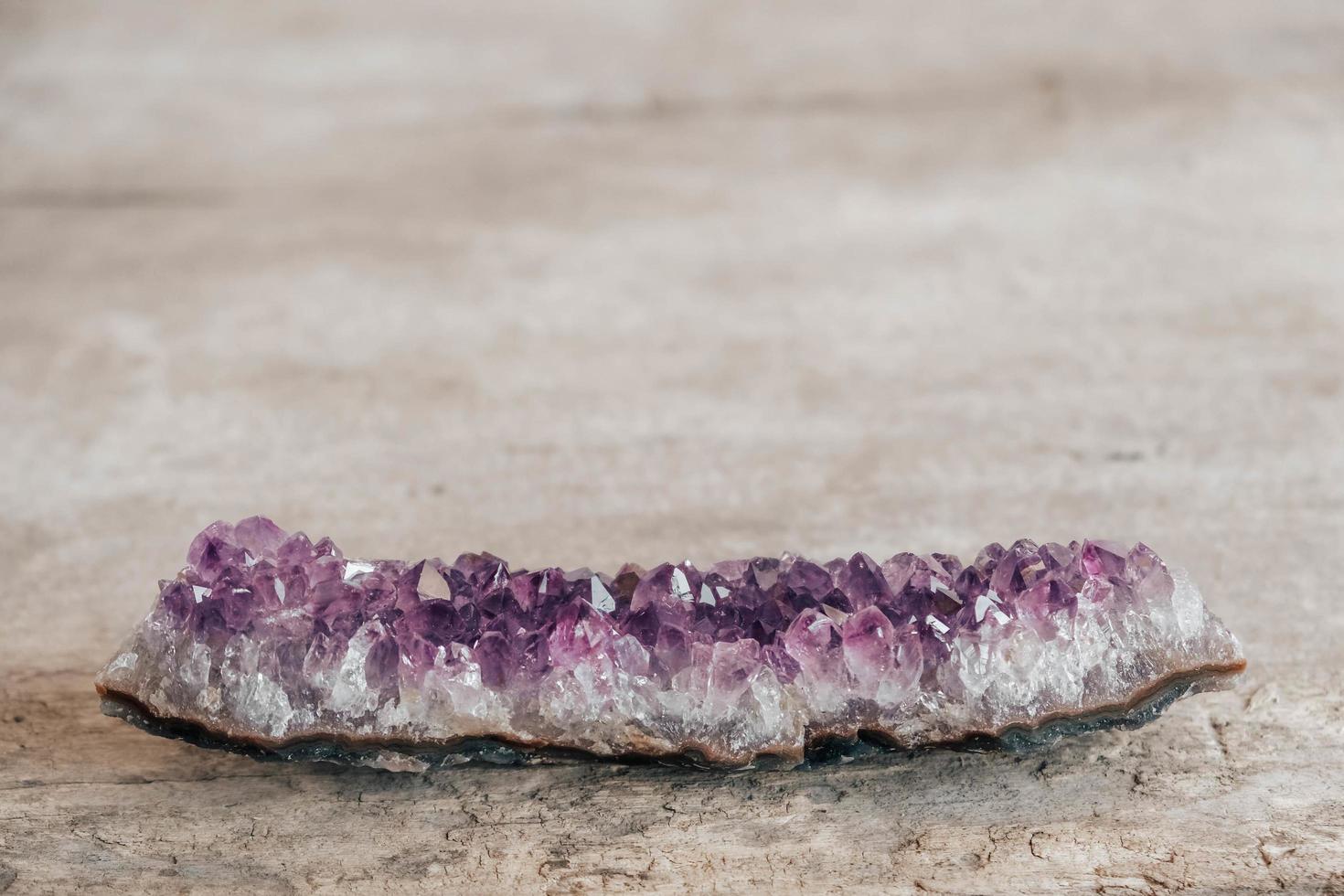 Violet amethyst crystal on wooden background photo