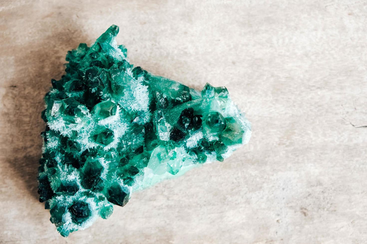 Raw emerald and gemstone rough rock crystal on a wooden table photo