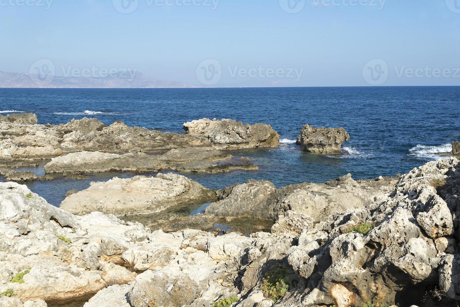 las olas rompiendo en una playa pedregosa, formando un rocío. olas y salpicaduras en la playa. olas rompiendo contra las rocas. foto