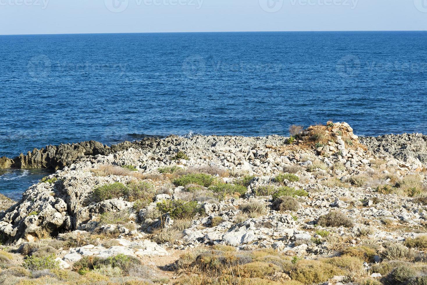 The waves breaking on a stony beach, forming a spray. Wave and splashes on beach. Waves crashing onto rocks. photo