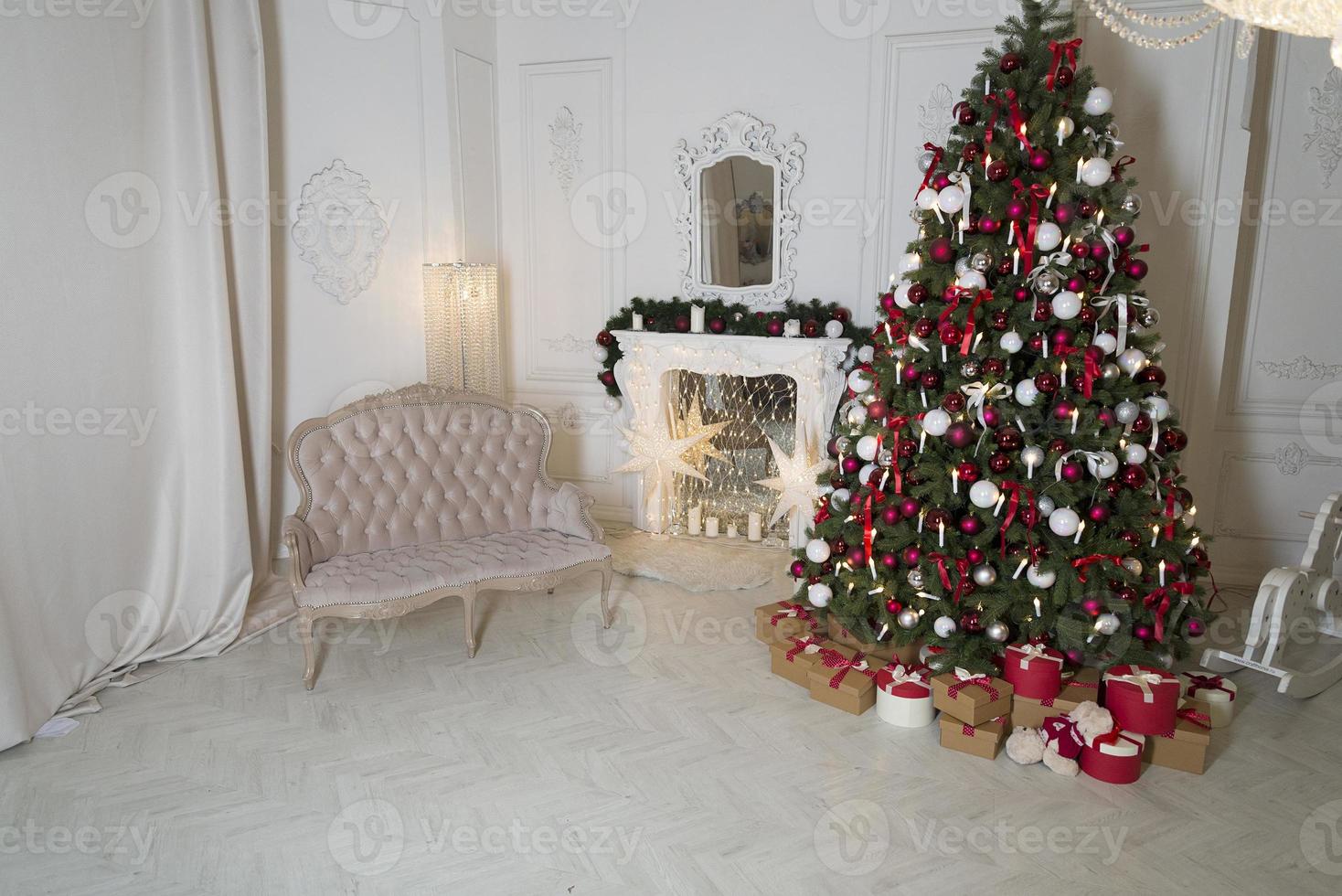 salón navideño con chimenea, sofá, árbol de navidad y regalos. hermoso interior de casa clásico decorado de año nuevo. foto