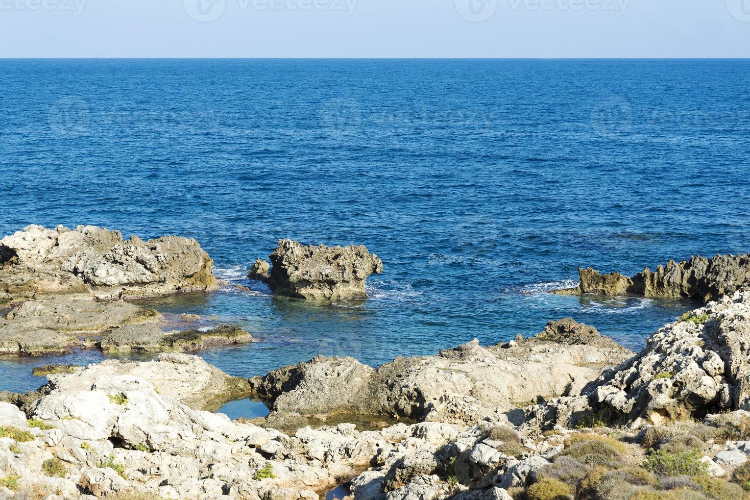 las olas rompiendo en una playa pedregosa, formando un rocío. olas y salpicaduras en la playa. olas rompiendo contra las rocas. foto