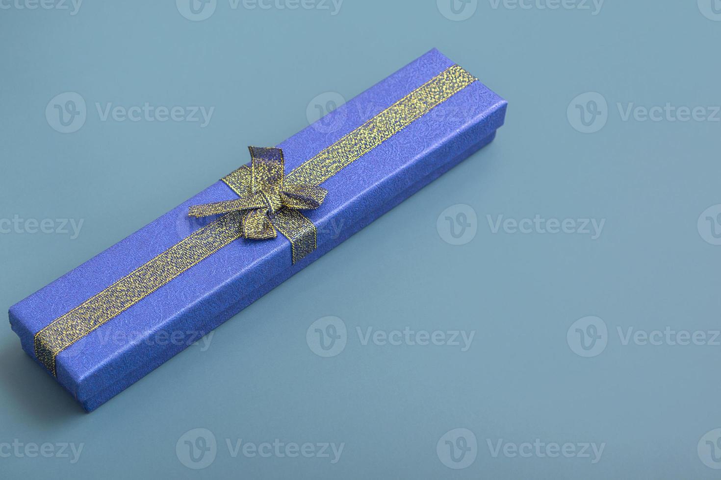 Gift blue box on a turquoise background. Holiday gifts closeup with copy space photo