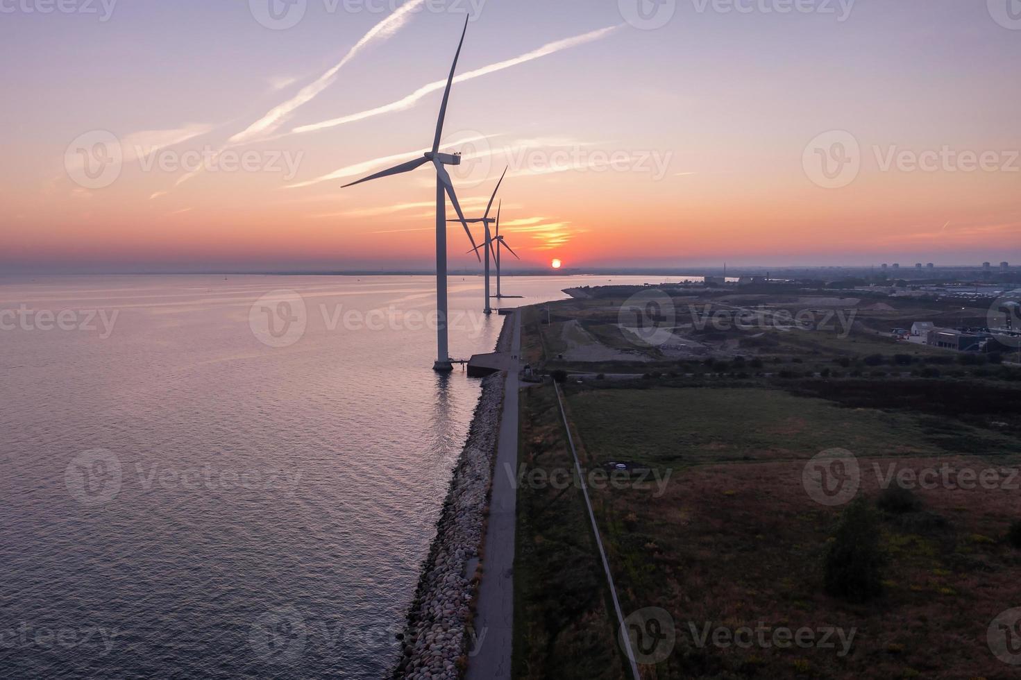 Aerial view of the wind turbines. Green ecological power energy generation. Wind farm eco field. Offshore and onshore windmill farm green energy at sea photo