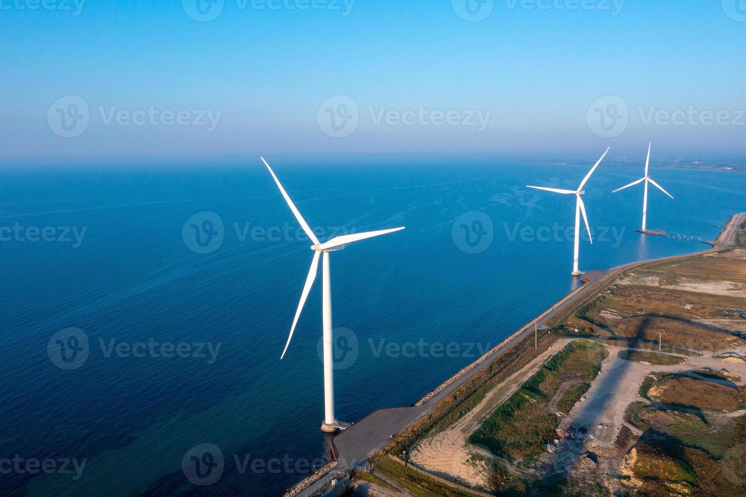 Aerial view of the wind turbines. Green ecological power energy generation. Wind farm eco field. Offshore and onshore windmill farm green energy at sea photo