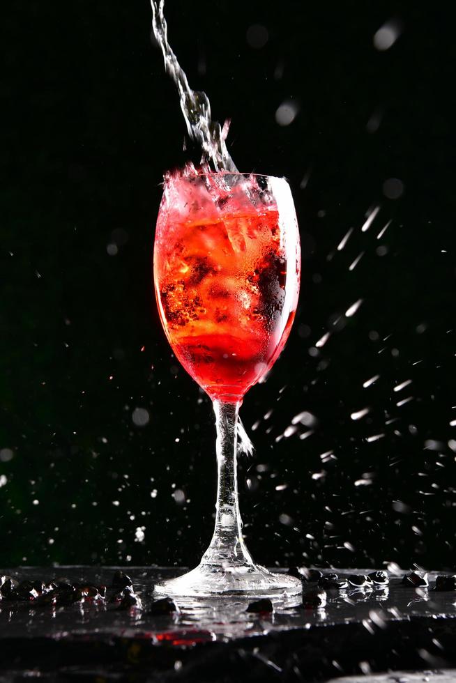 Alcoholic cocktails consisting of red fruit juices and soda water. Poured into a glass of wine by a professional bartender. photo