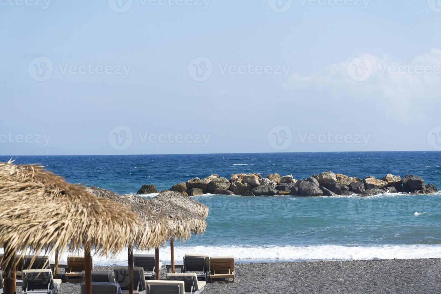 Parasol and veil that is spread on the pebbles on the beach near the sea photo