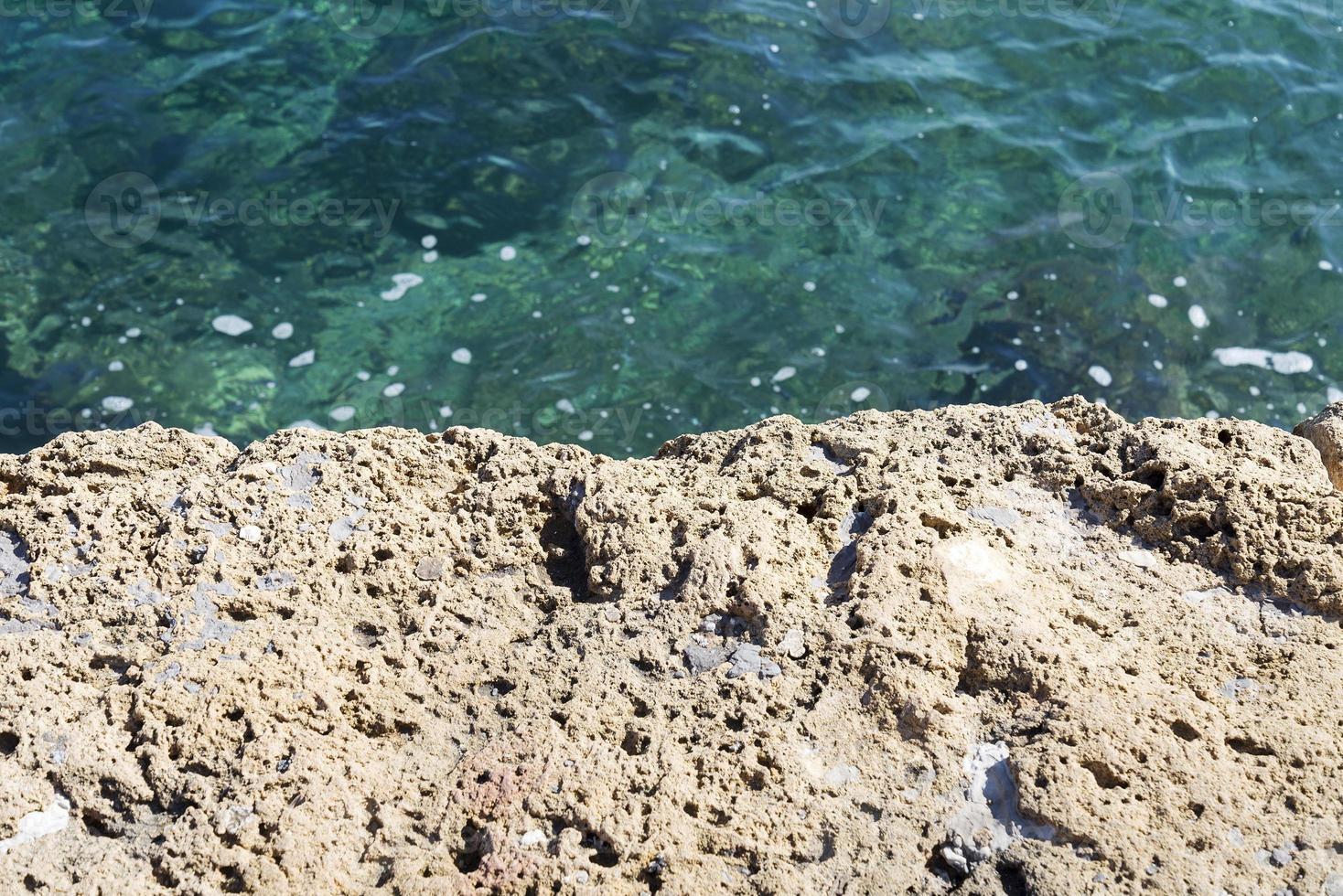 A stone slab near the sea. The texture of the water and stone. photo