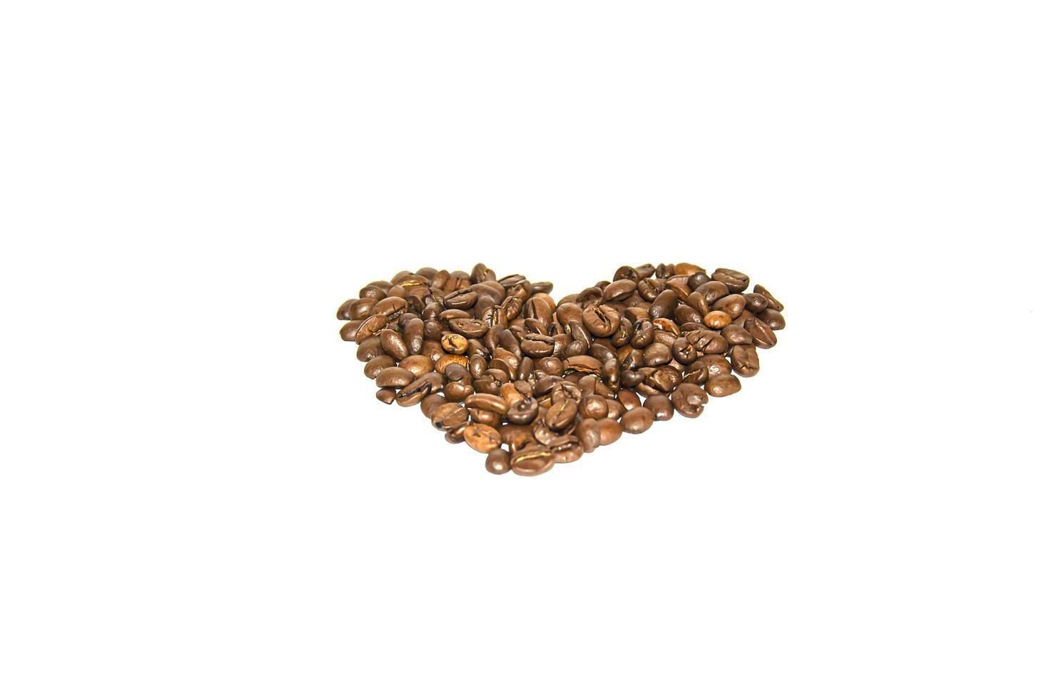 Coffee beans spread out in the shape of a heart on a white background. Isolate. Lifestyle photo