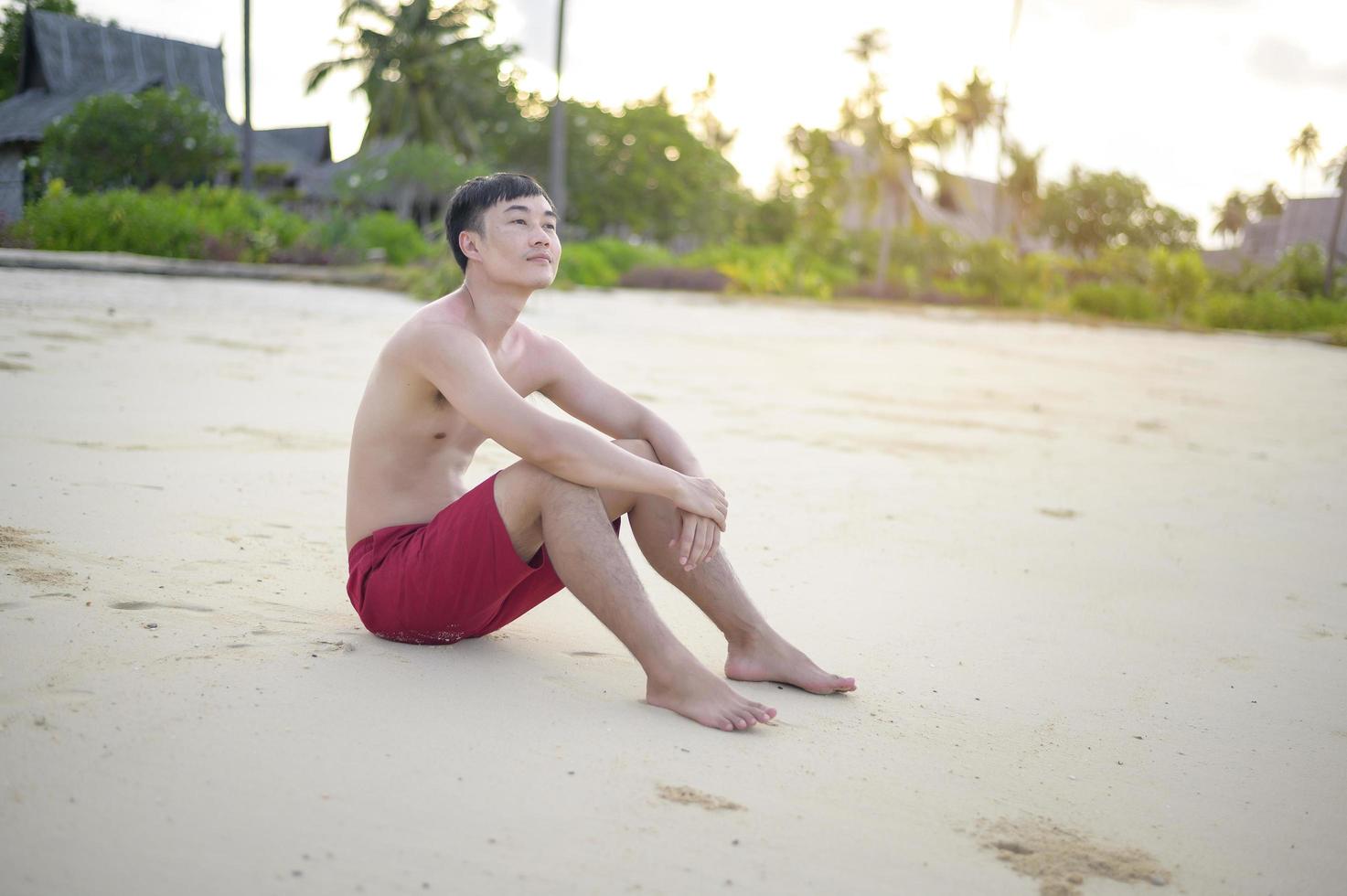 hombre feliz disfrutando y relajándose en el concepto de playa, verano y vacaciones foto