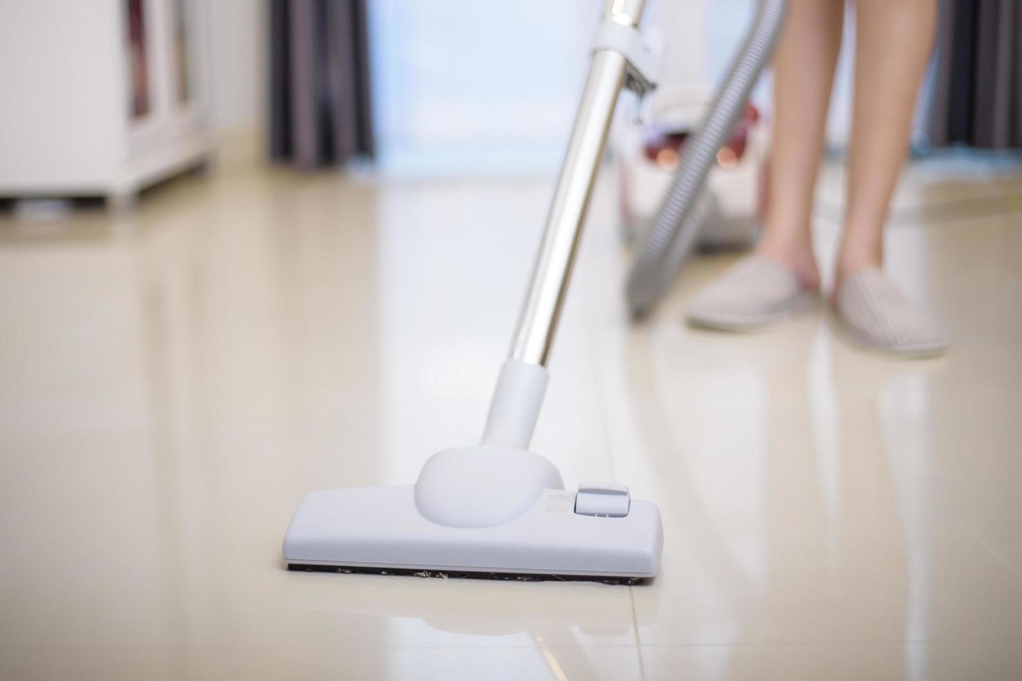 woman is cleaning house with vacuum machine photo