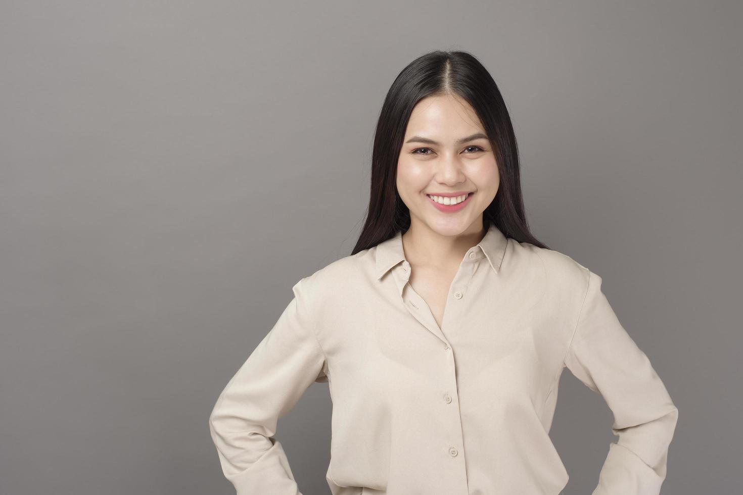 Portrait of beautiful business woman smiling on gray background photo