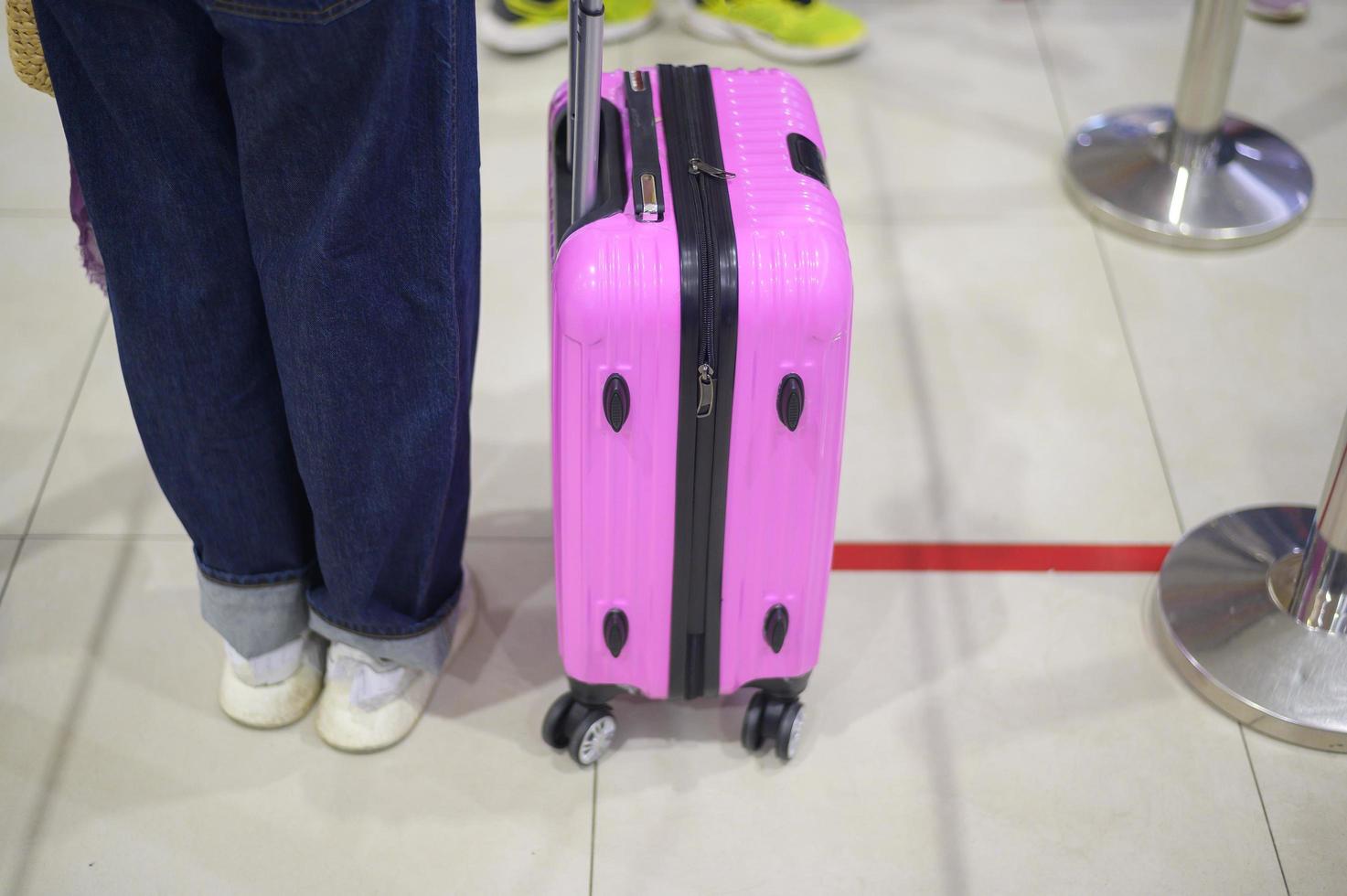 Passenger stand in line on the floor at the check in counter to maintain social distance due to coronavirus pandemic safety guideline photo