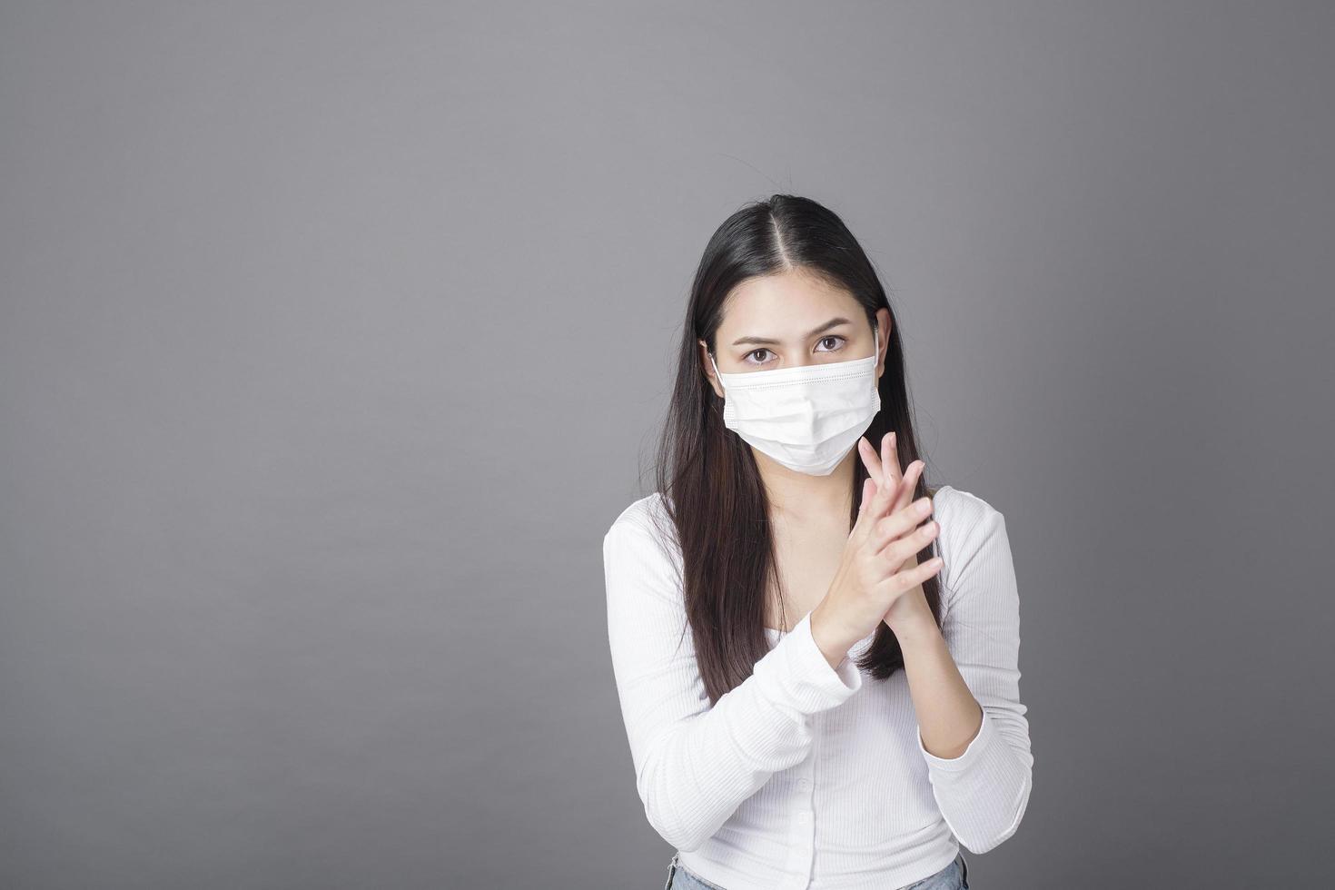 Portrait of woman with surgical mask using alcohol gel sanitizer photo