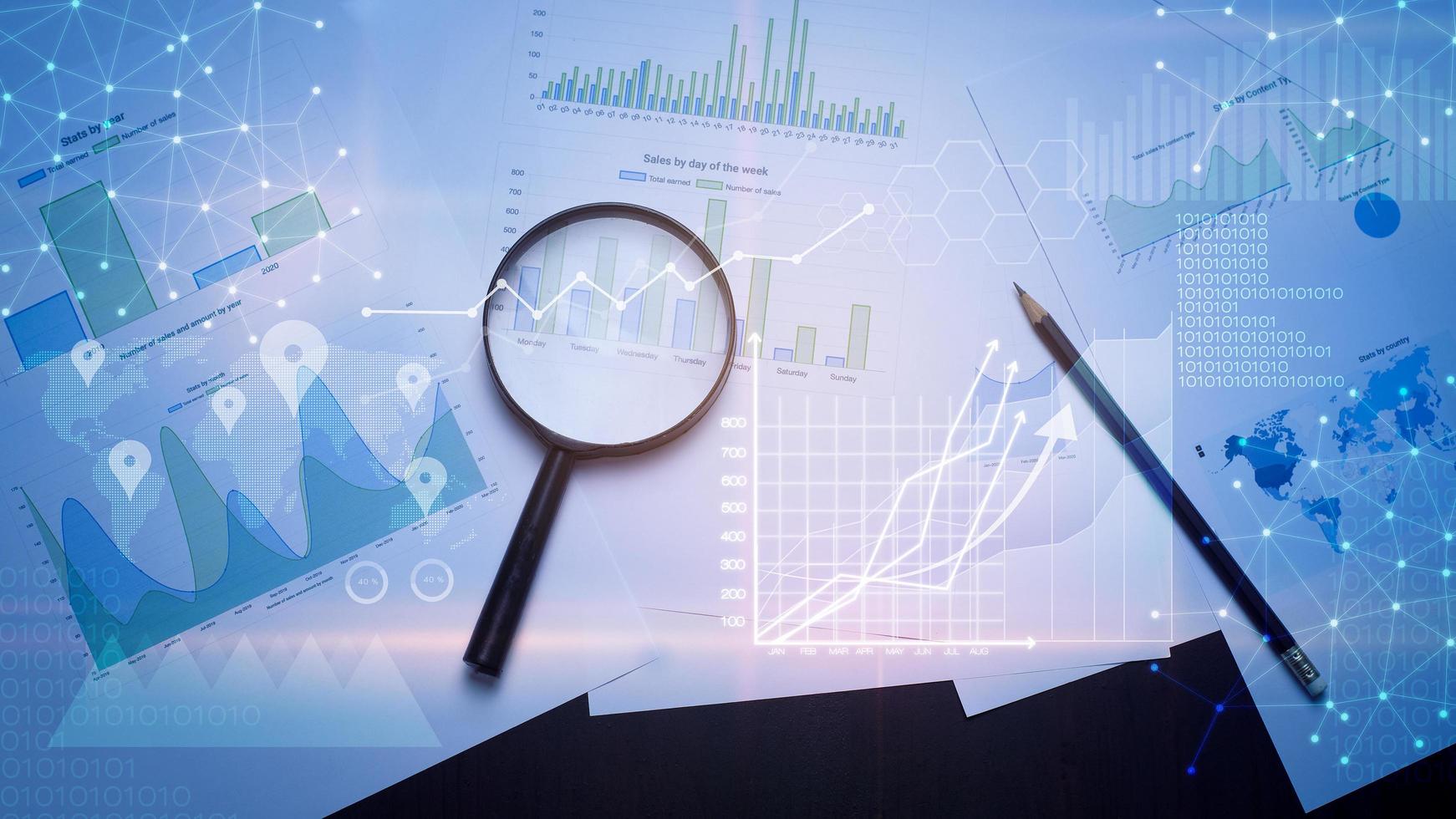 lupa y documentos con datos analíticos sobre la mesa foto