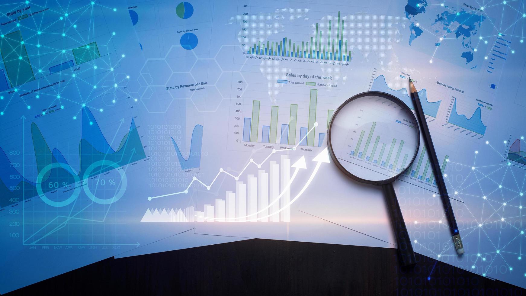 Magnifying glass and documents with analytics data lying on table , and digital virtual reality graph photo