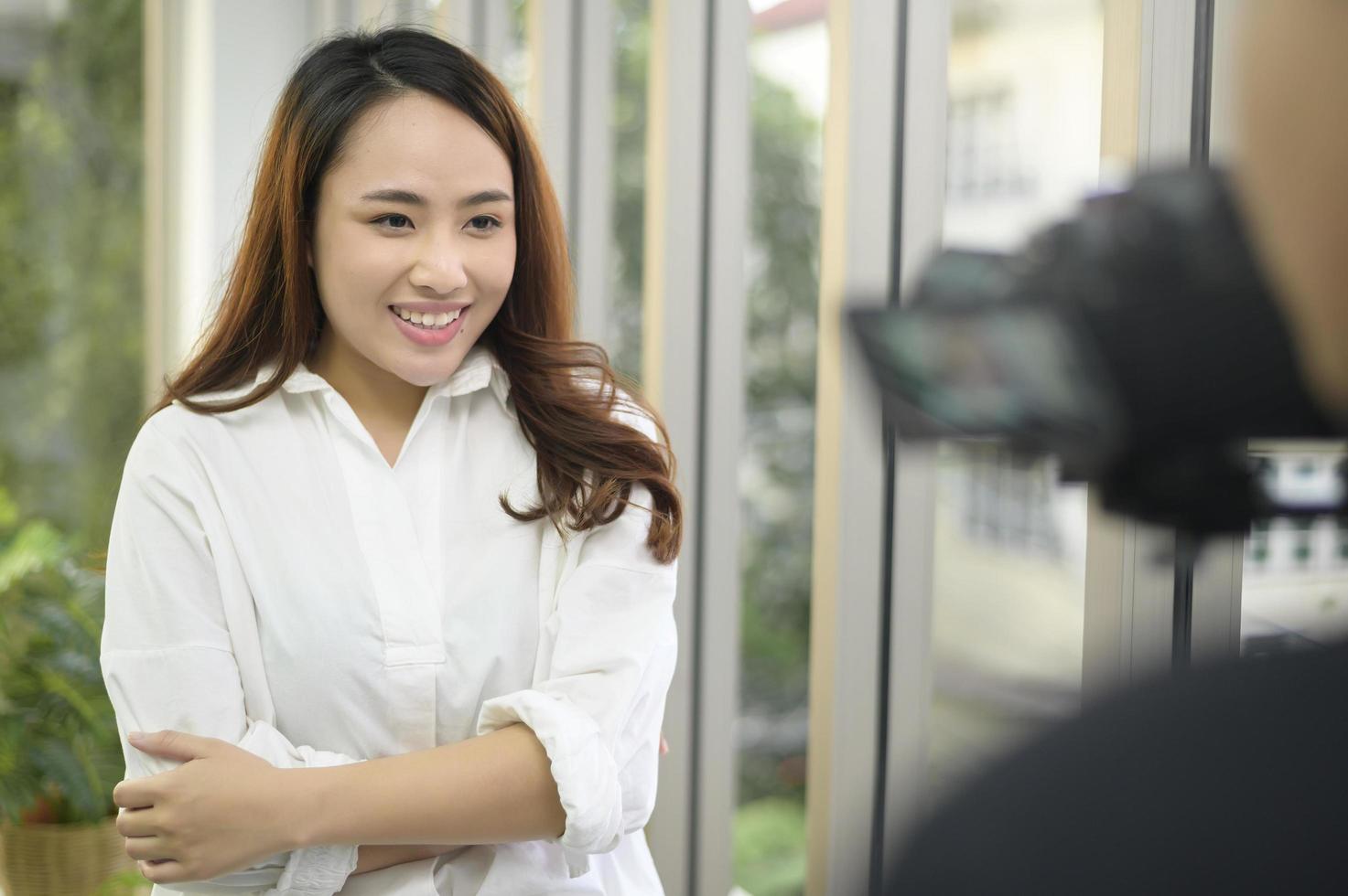 Video camera recording of confident beautiful businesswoman being interviewed, behind the scene concept, photo