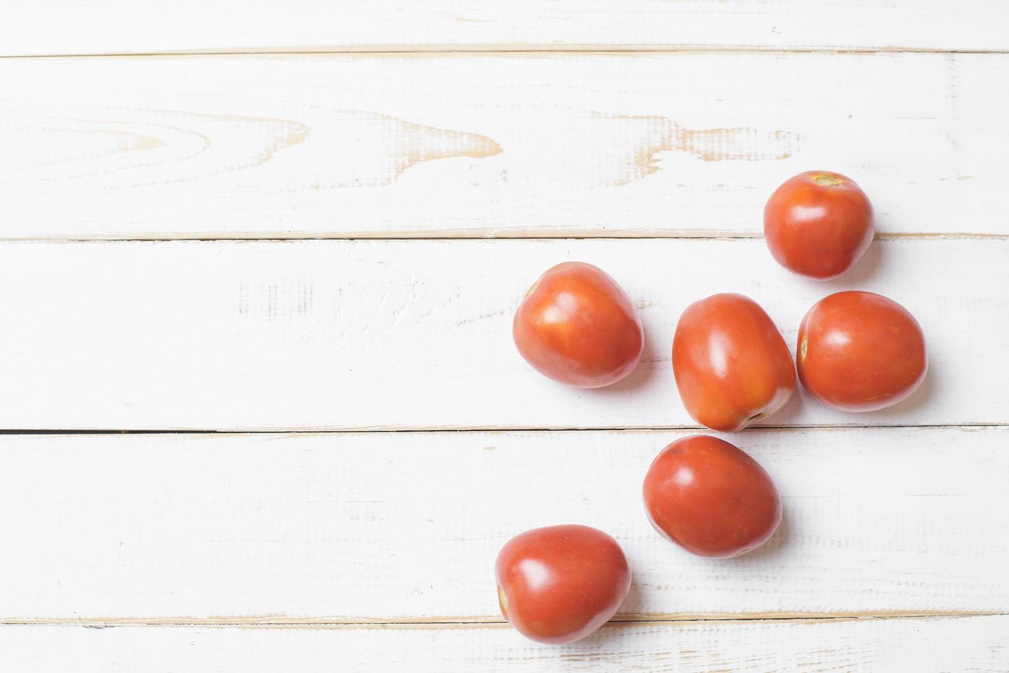 Tomato on white wooden background. photo