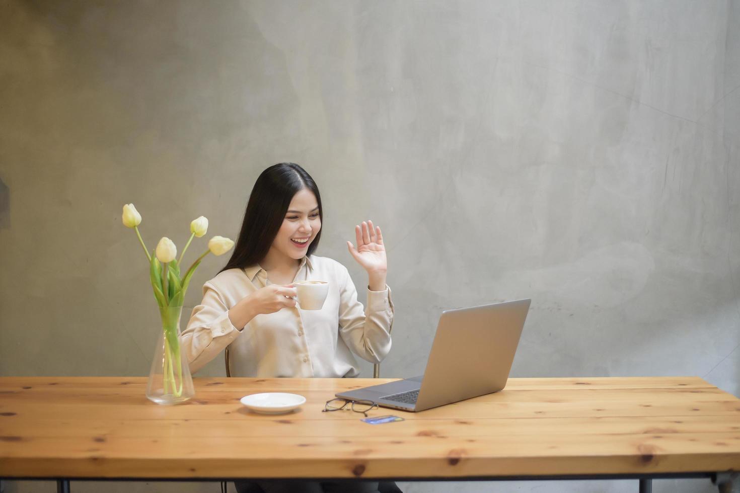 bella mujer de negocios está trabajando con una laptop en una cafetería foto