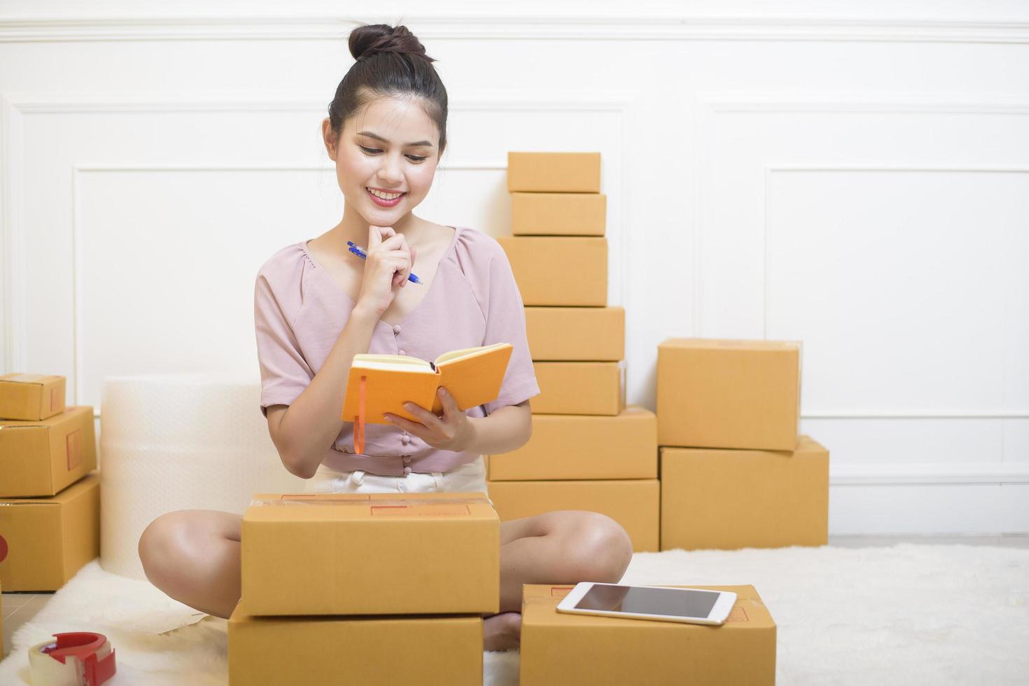 a woman is preparing products with cardboard boxes for shipping. photo