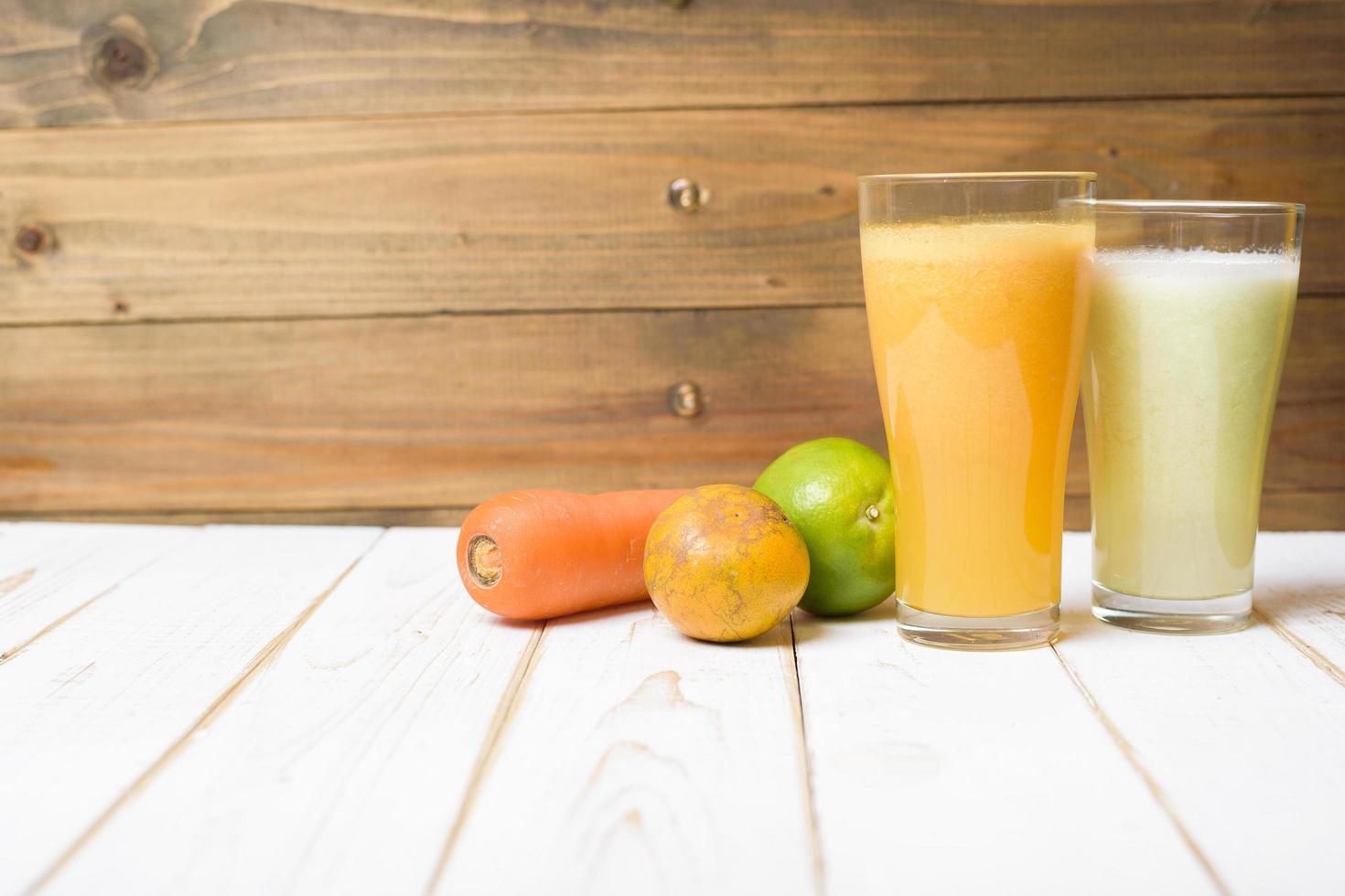 Jugo de frutas y verduras de dieta saludable listo para beber en mesa de madera foto