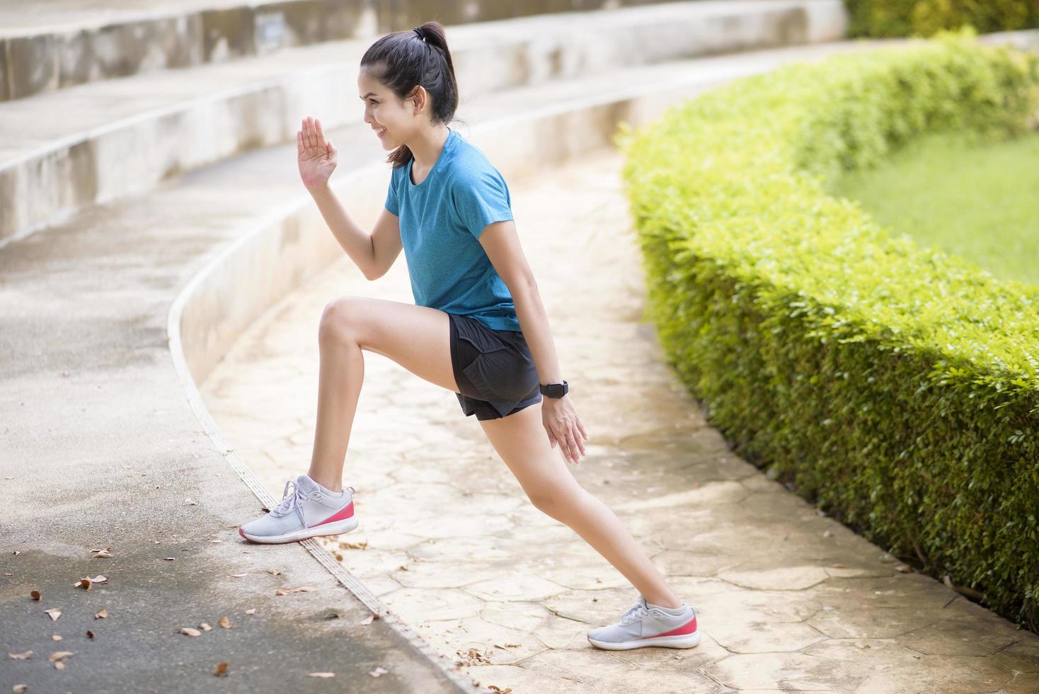 una joven feliz con ropa deportiva hace ejercicio en el parque foto