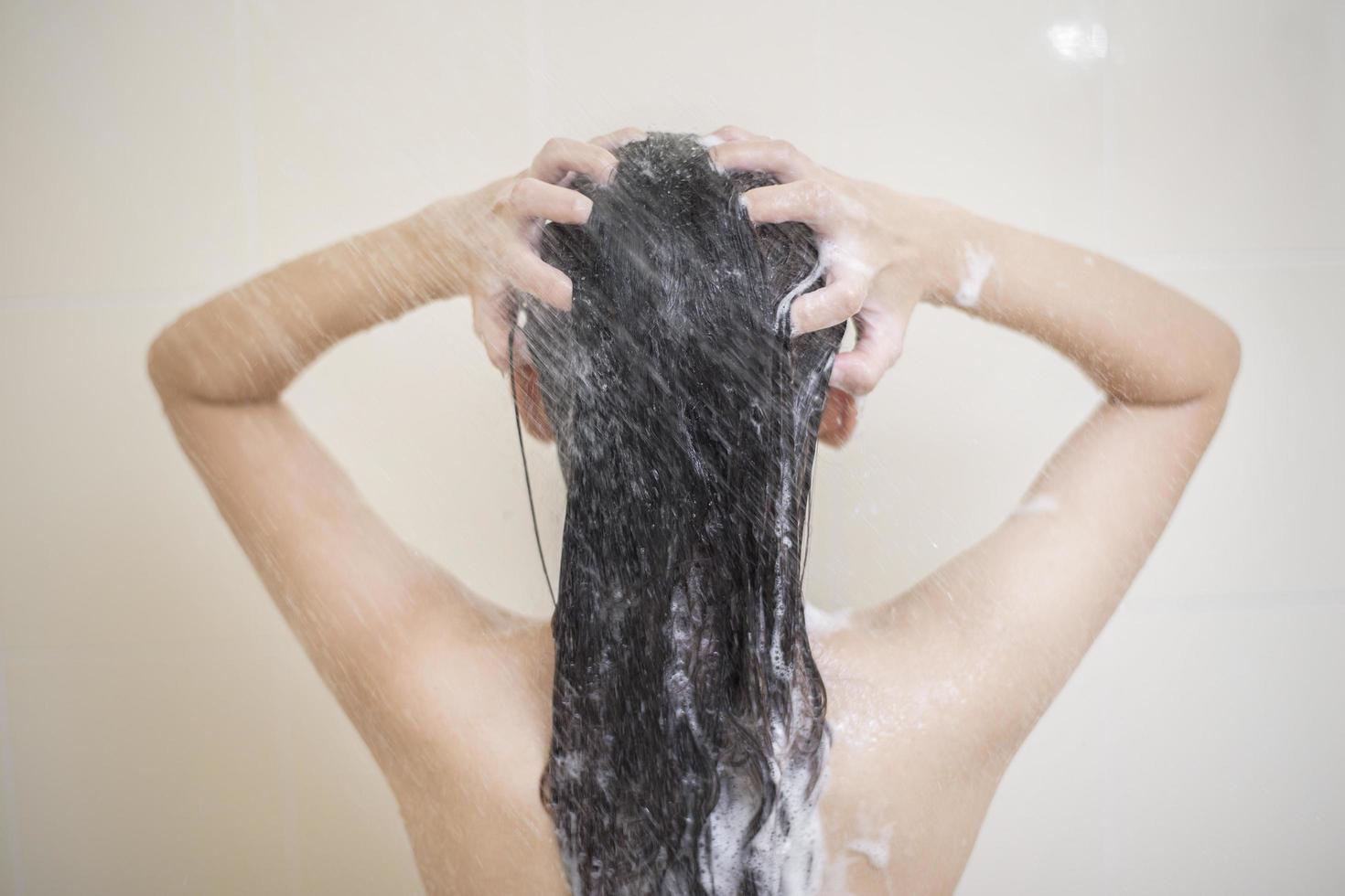 una mujer feliz y hermosa se está duchando foto