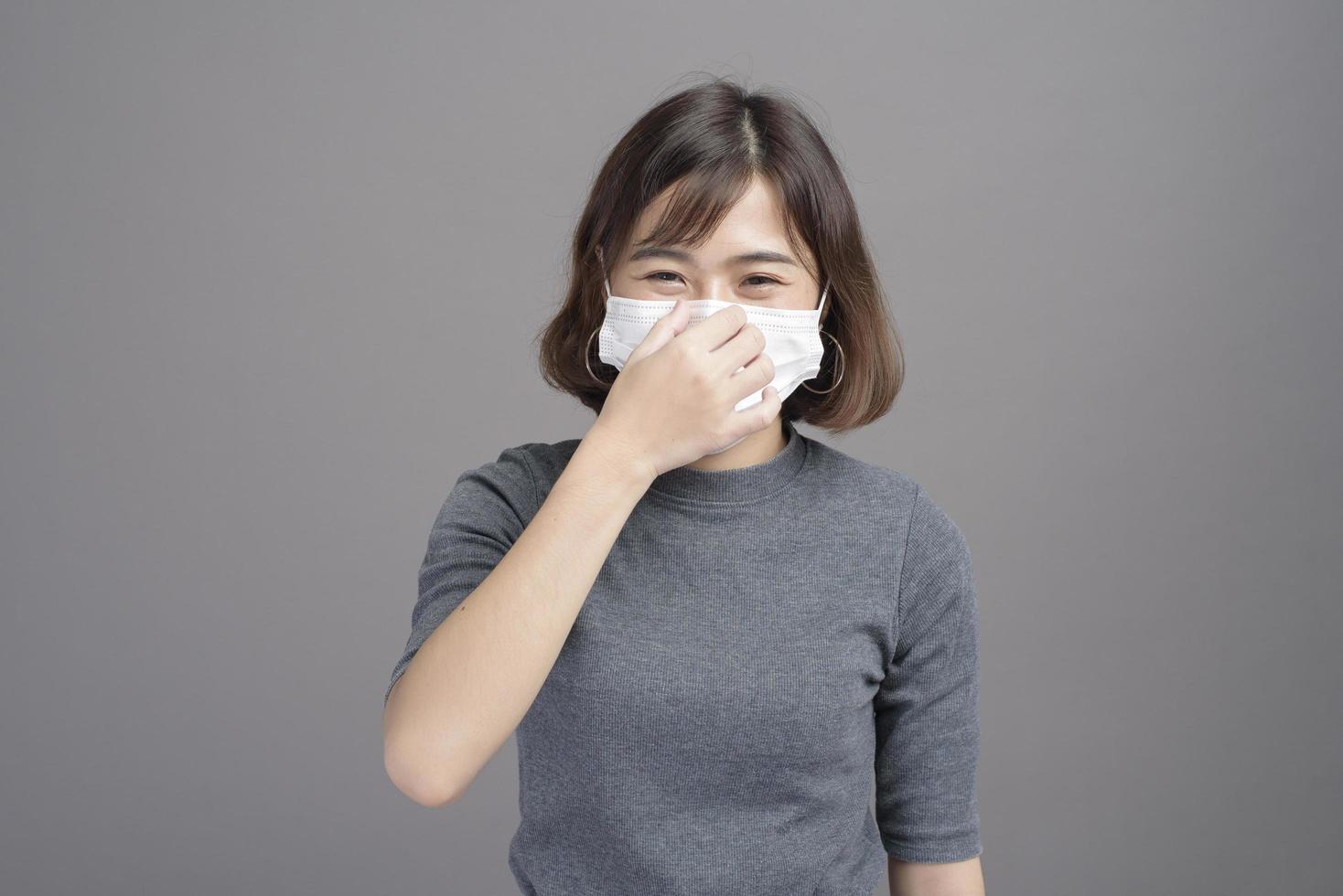 retrato de una joven y hermosa mujer asiática con una máscara quirúrgica sobre los antecedentes del estudio covid19 pandemia y contaminación del aire foto