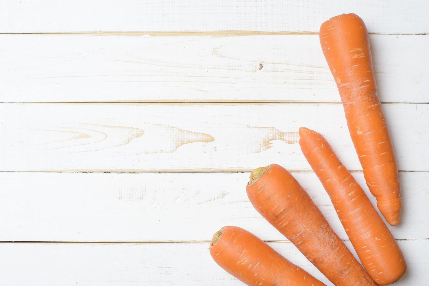 Carrot on white wooden table. photo
