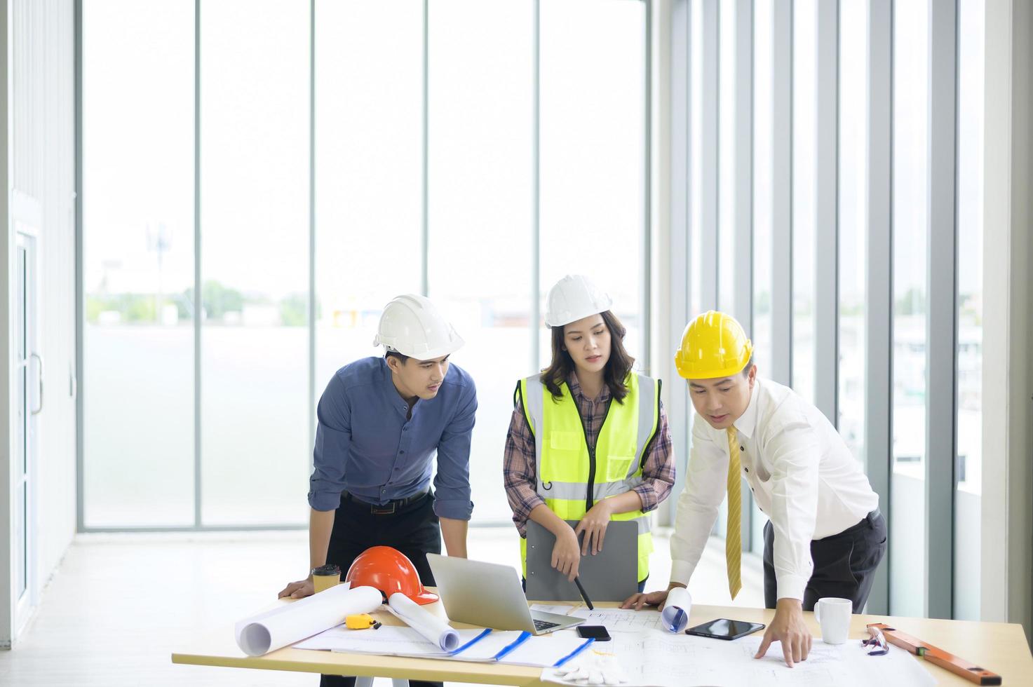 los ingenieros son planes de construcción analíticos con planos en la oficina foto