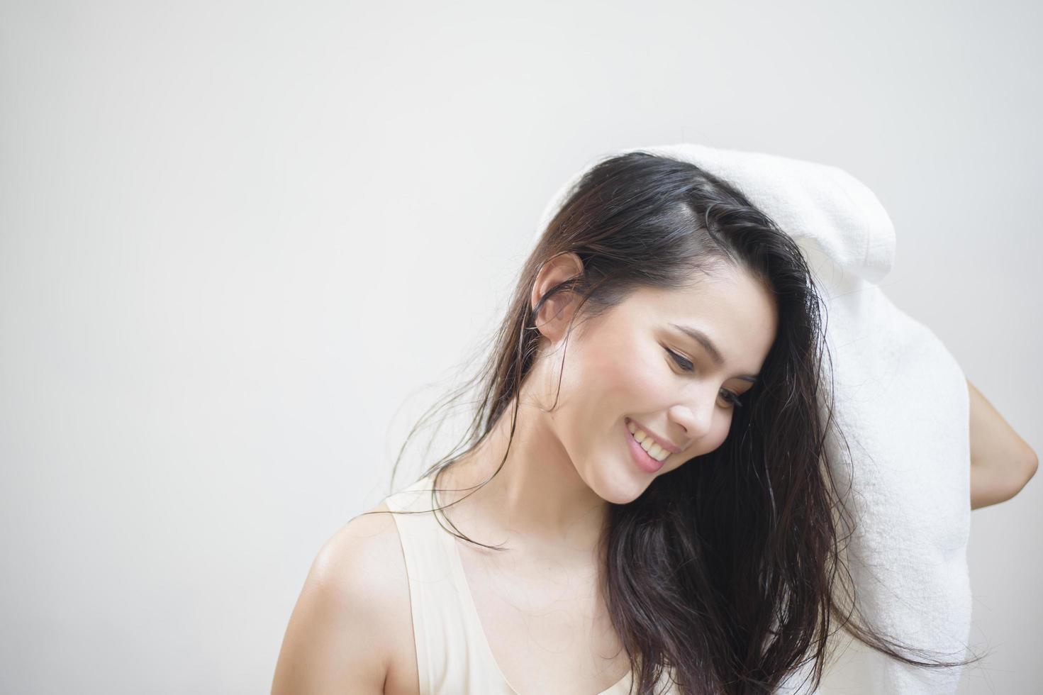 A woman is drying her hair with a towel after showering photo