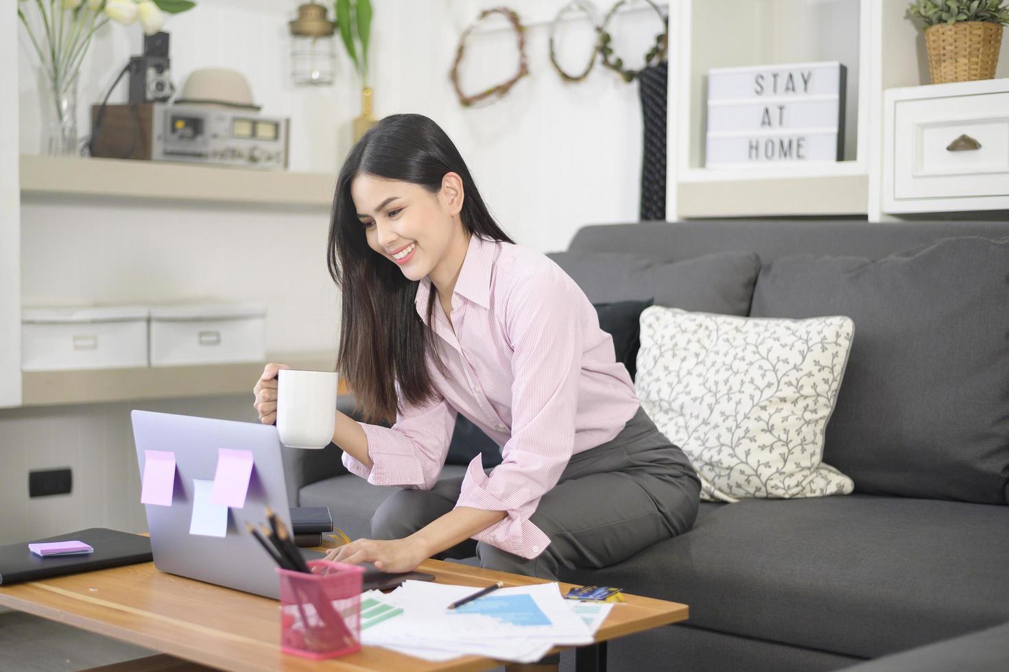 una mujer de negocios está trabajando con una computadora portátil y analizando datos de gráficos de crecimiento empresarial en la sala de estar, trabajo desde casa, concepto de tecnología empresarial. foto