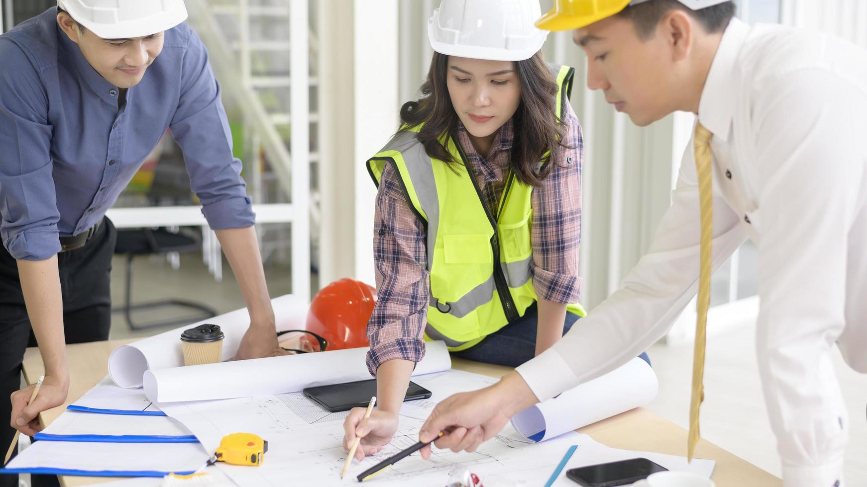Engineering people are analytics construction plans with blueprint in office photo