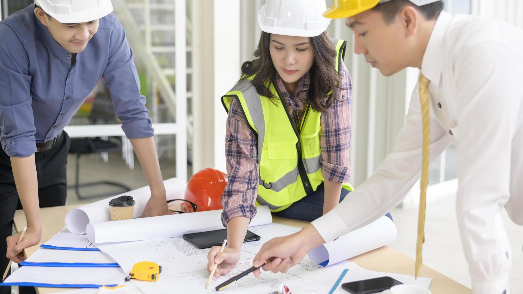 los ingenieros son planes de construcción analíticos con planos en la oficina foto