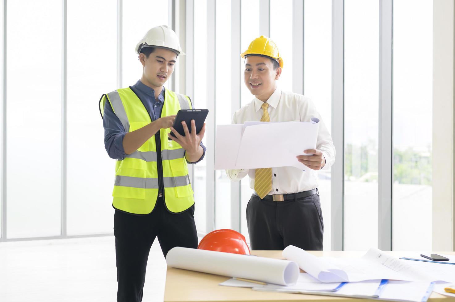 los ingenieros son planes de construcción analíticos con planos en la oficina foto