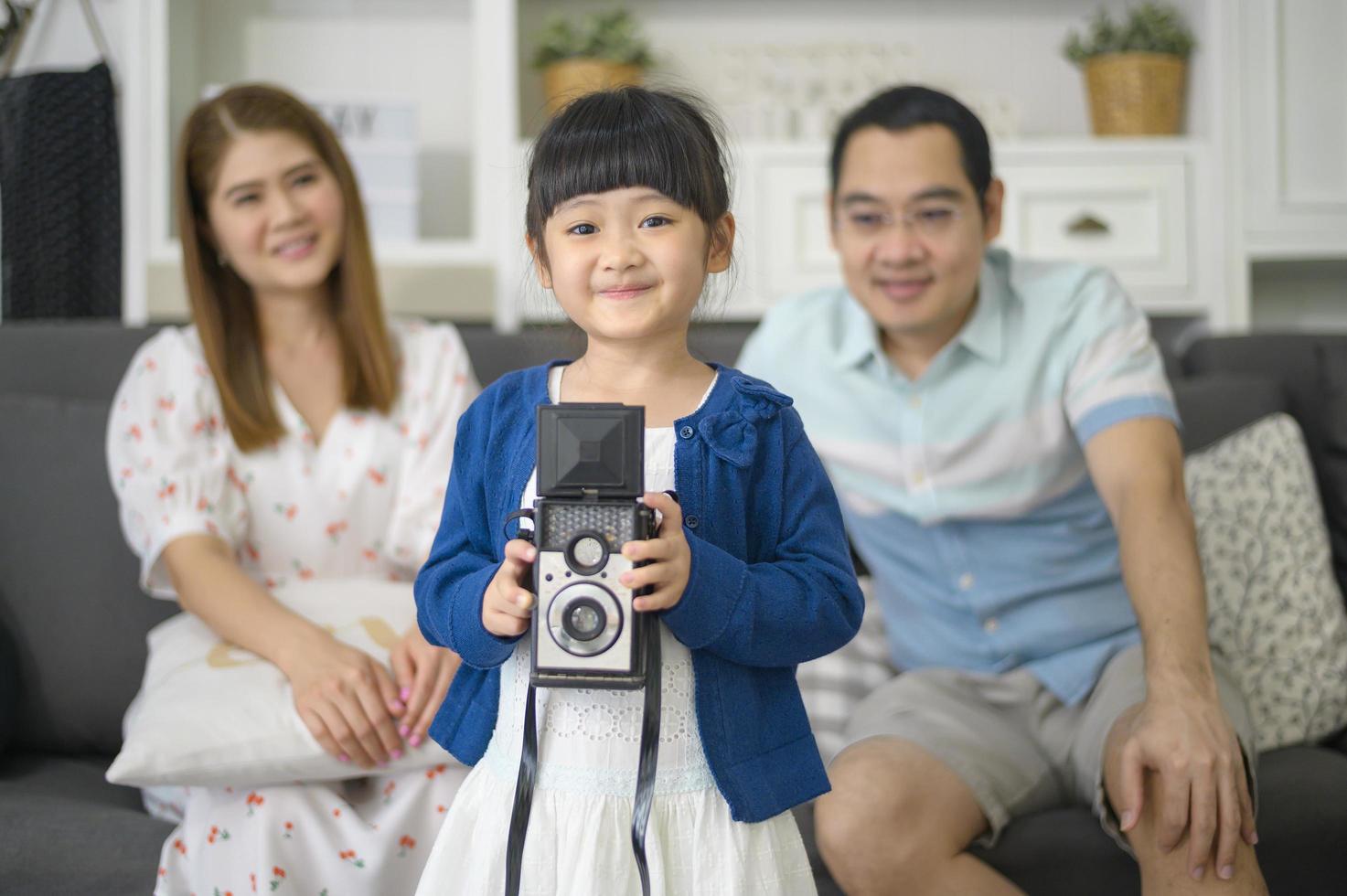 a cute Asian daughter holding camera is taking photos of her parents at home on weekends.