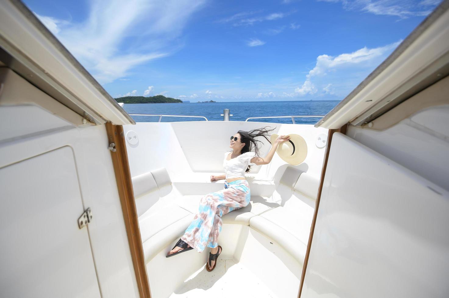 turista emocionado disfrutando y relajándose en lancha rápida con una hermosa vista del océano y la montaña en el fondo foto