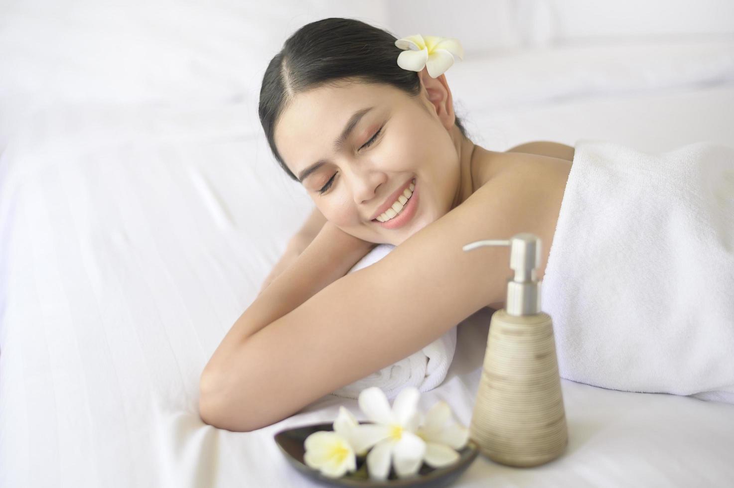 una mujer hermosa se relaja y recibe un masaje en un balneario, un masaje y un concepto de tratamiento de belleza. foto