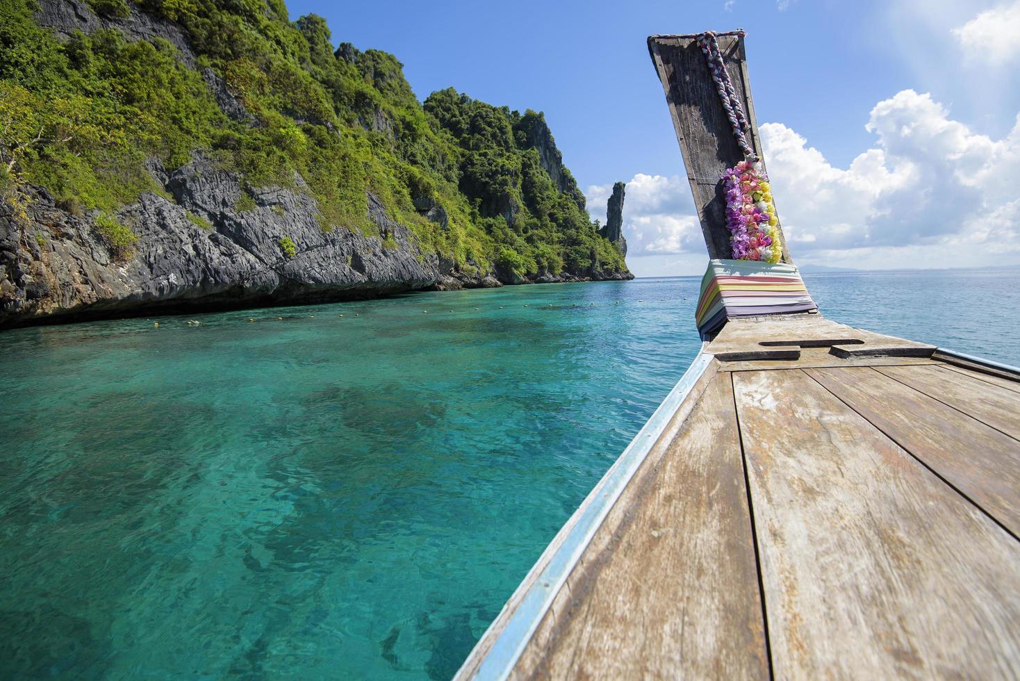 vista del barco de cola larga tradicional tailandés sobre el mar claro y el cielo en el día soleado, islas phi phi, tailandia foto