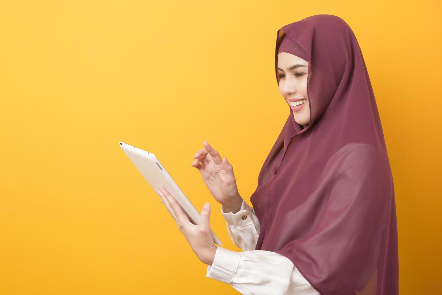 Beautiful University student with hijab portrait on yellow background photo