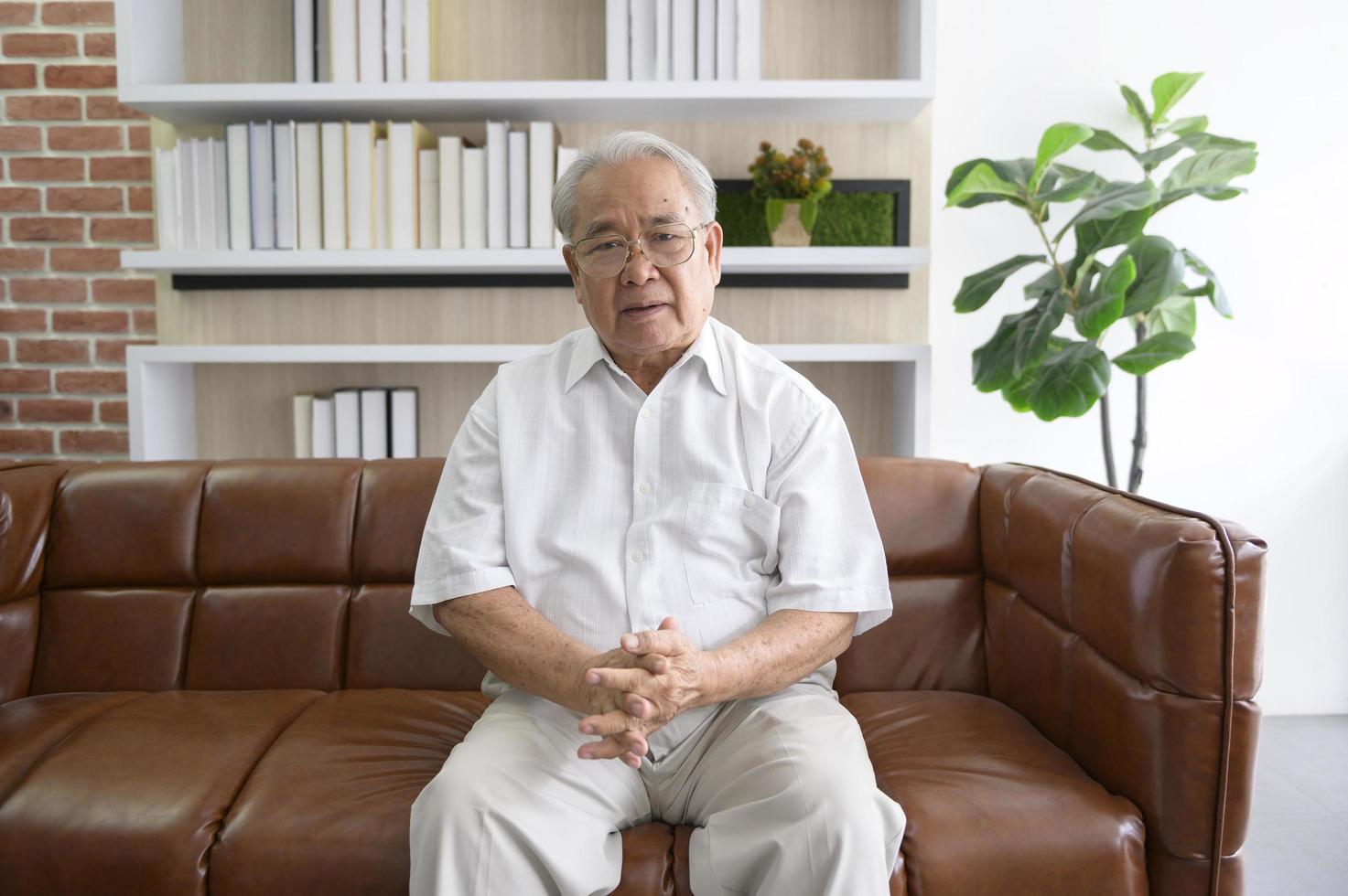 Senior Asian man making video call on social network with doctor consulting about health problems, head shot close up portrait. photo