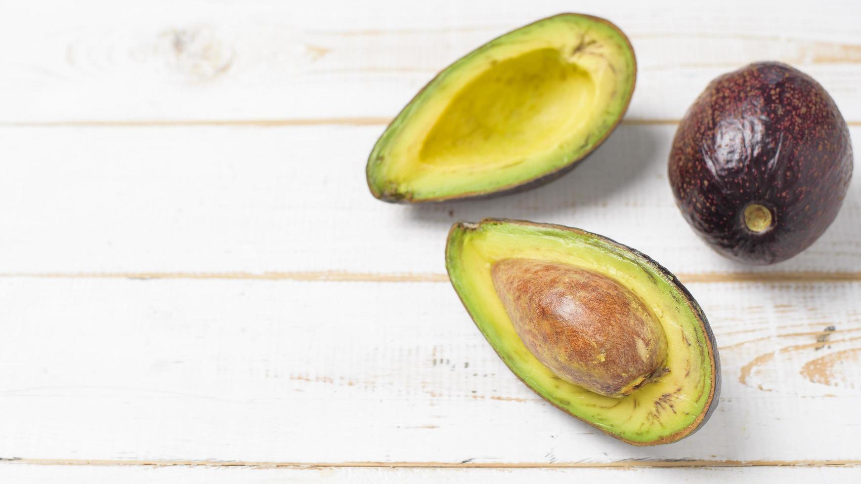 Avocado on white wooden table photo