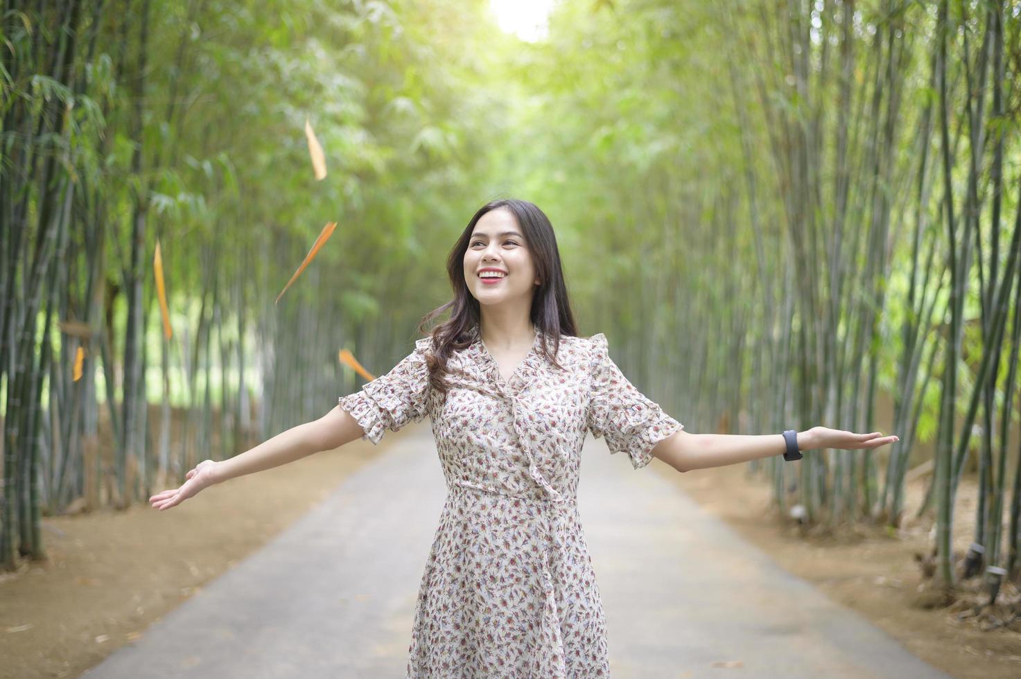young woman is open arms in the green nature background. photo