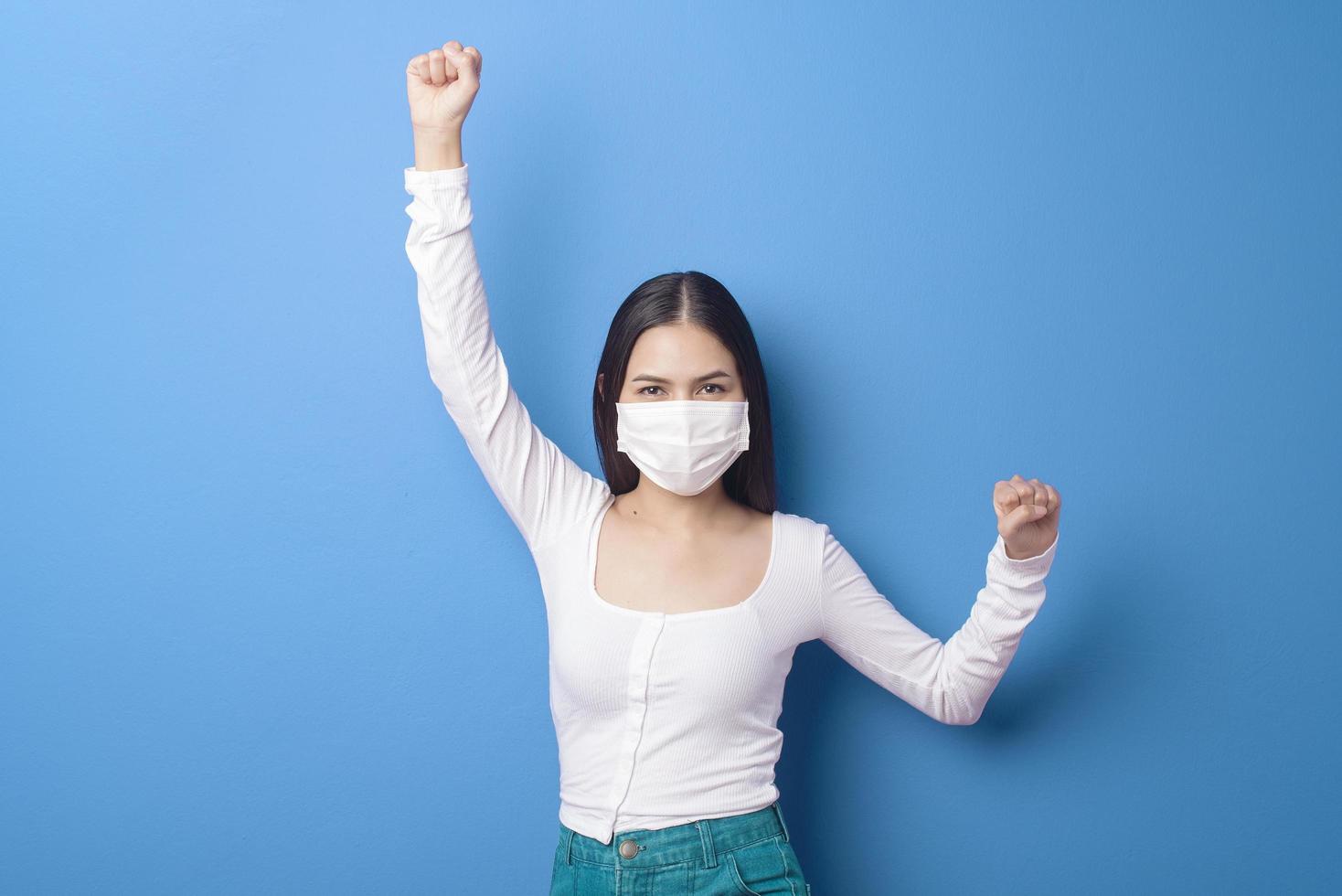 retrato de mujer joven lleva máscara facial sobre fondo azul foto