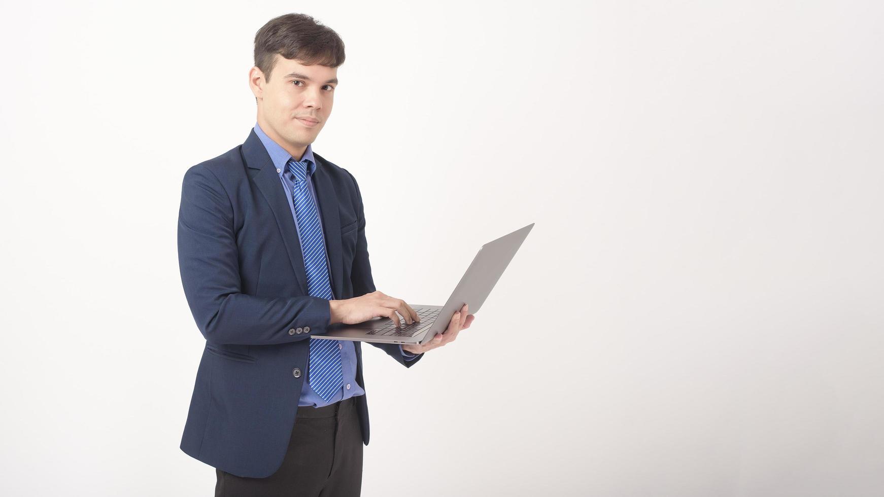 retrato de un joven hombre de negocios está usando una laptop sobre un estudio de fondo blanco foto