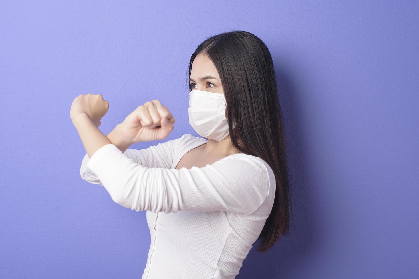 retrato de mujer joven lleva máscara facial sobre fondo morado foto