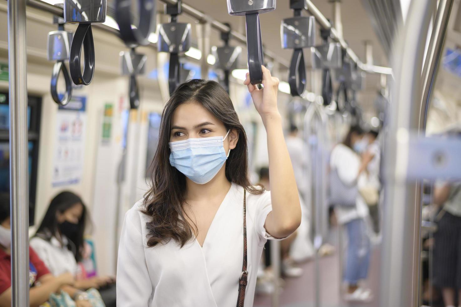 una mujer joven lleva una máscara protectora en el metro , protección covid-19 , viajes de seguridad , nueva normalidad , distanciamiento social , transporte de seguridad , viajes bajo el concepto de pandemia foto