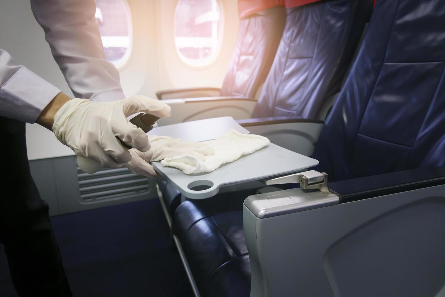 Close up hand is wearing gloves cleaning aircraft seat for covid-19 prevention pandemic photo