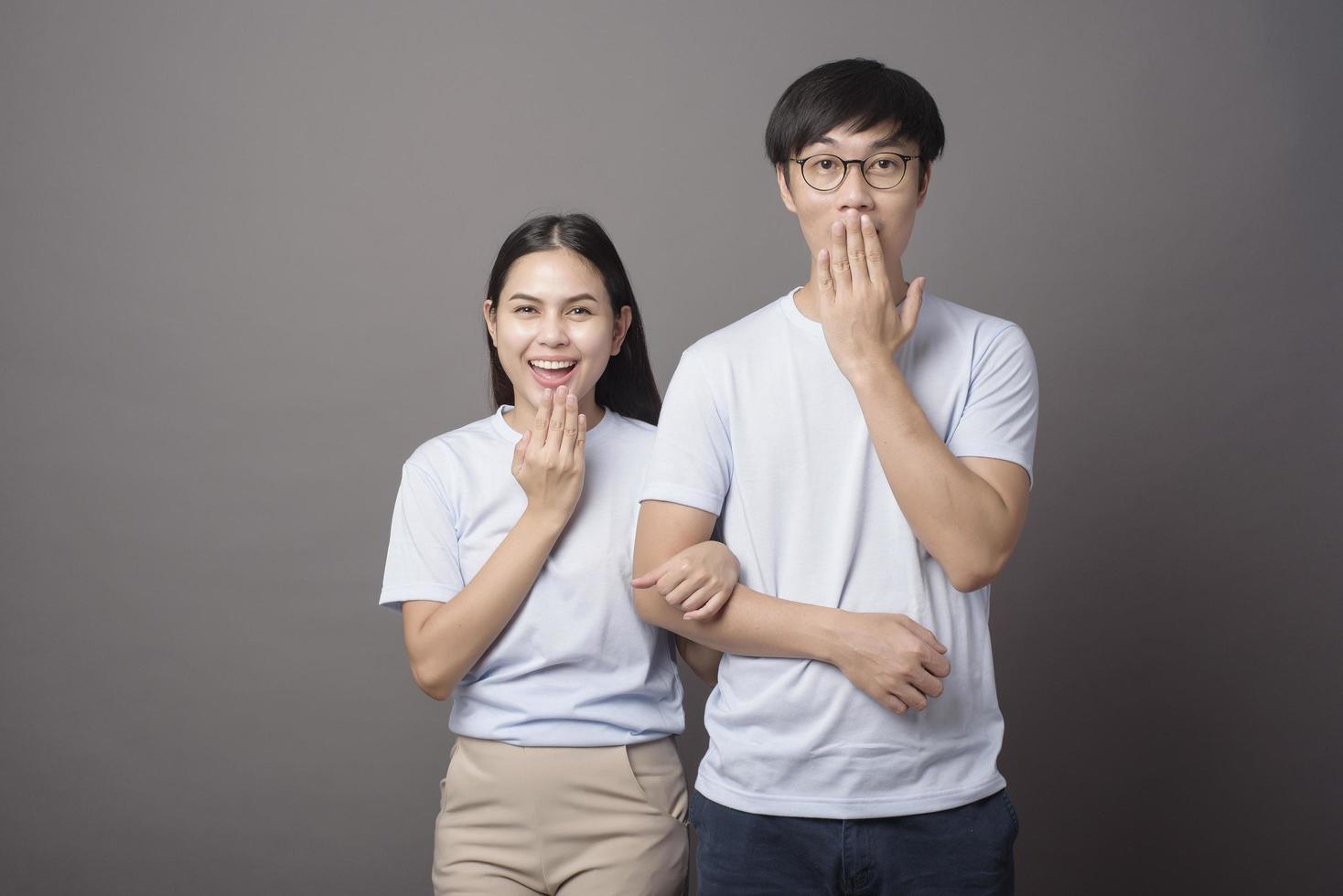 a portriat of a happy couple wearing blue shirt is enjoying over grey background studio photo