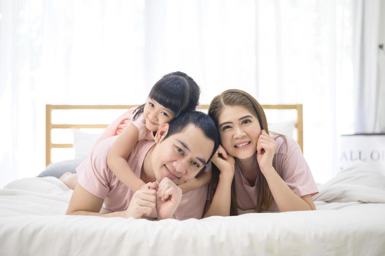 portrait of happy Asian family in white bedroom photo